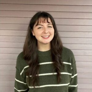 A woman wearing a green and white striped sweater.